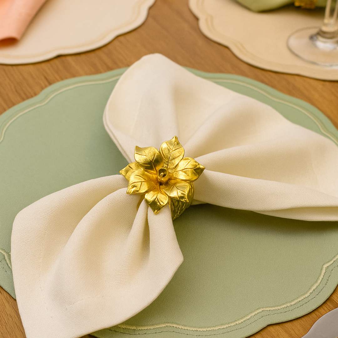 Blossom Napkin Rings - A set of napkin rings with silver and gold colors, featuring a floral design, displayed on a dining table from House of Pehr
