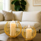 Two Aura Candle Holders with lit candles on a table in a living room setting from House of Pehr