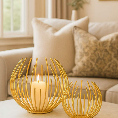 Two decorative Aura candle holders on a table with a plant and sofa in the background from House of Pehr