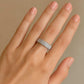 Hand wearing a silver Orbit ring on a beige background