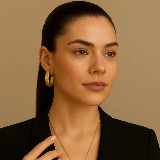 Woman wearing gold Orbit hoop earrings with a neutral background from House of Pehr