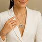 Woman wearing the Orbit silver necklace, ring, and bracelet against a beige background from House of Pehr