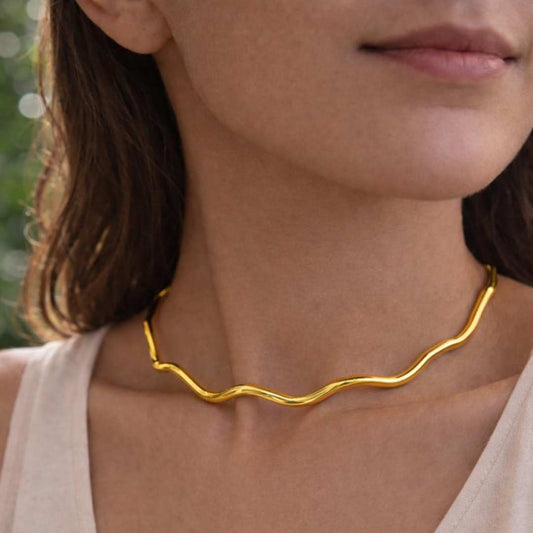 Gold necklace worn by a person from House of Pehr