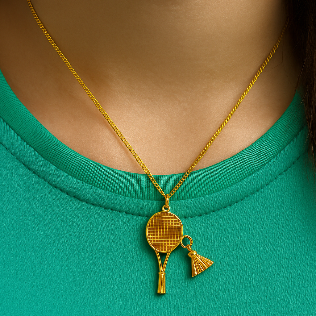 Gold necklace with a badminton racket pendant next to a badminton shuttlecock and racket on a dark surface from House of Pehr