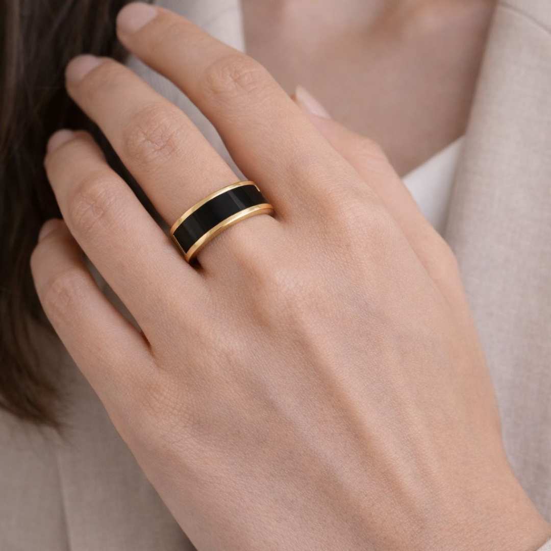 Hand wearing a black and gold ring on a light background - Noire Ring - house of pehr