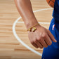 Gold bracelet with a shoe charm on a white background, basketball bracelet