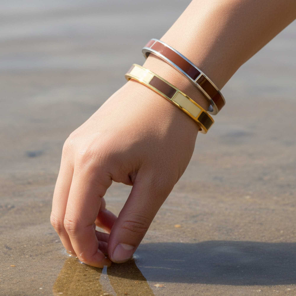 Stacked Dune Gold bangle on a wrist against a beige background - Image 4