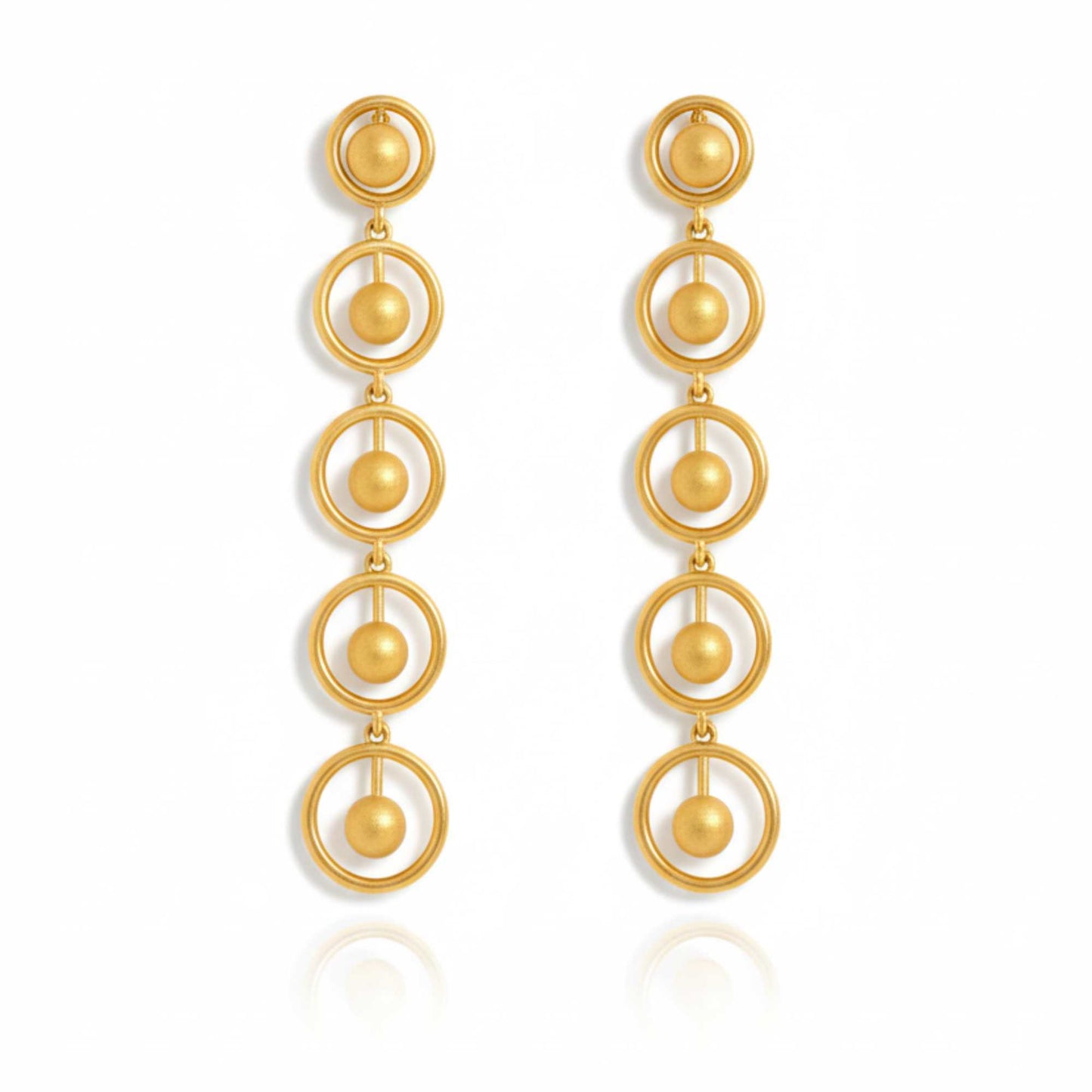 Gold earrings with circular design on a white background, solara earrings from house of pehr