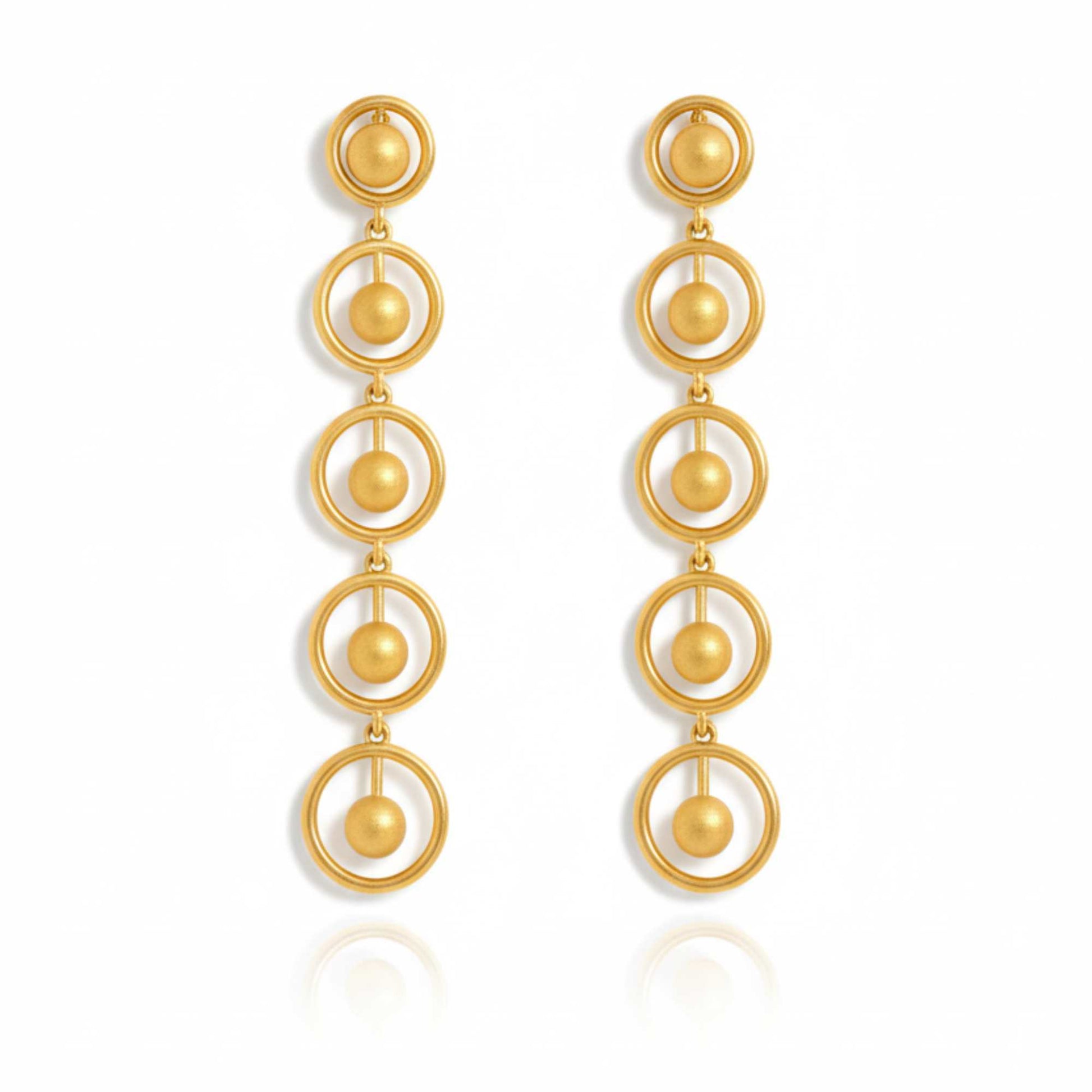 Gold earrings with circular design on a white background, solara earrings from house of pehr