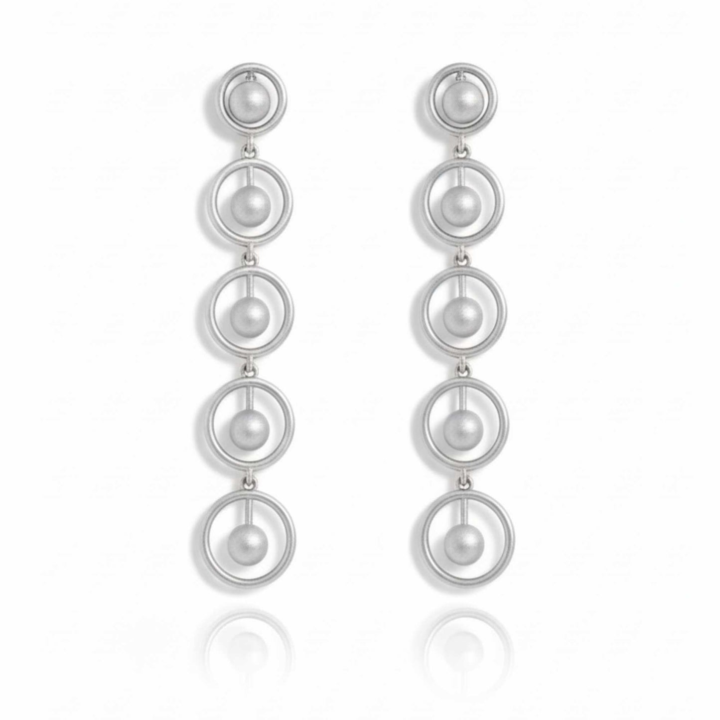 Silver earrings with multiple circular loops on a white background. solara earrings from house of pehr