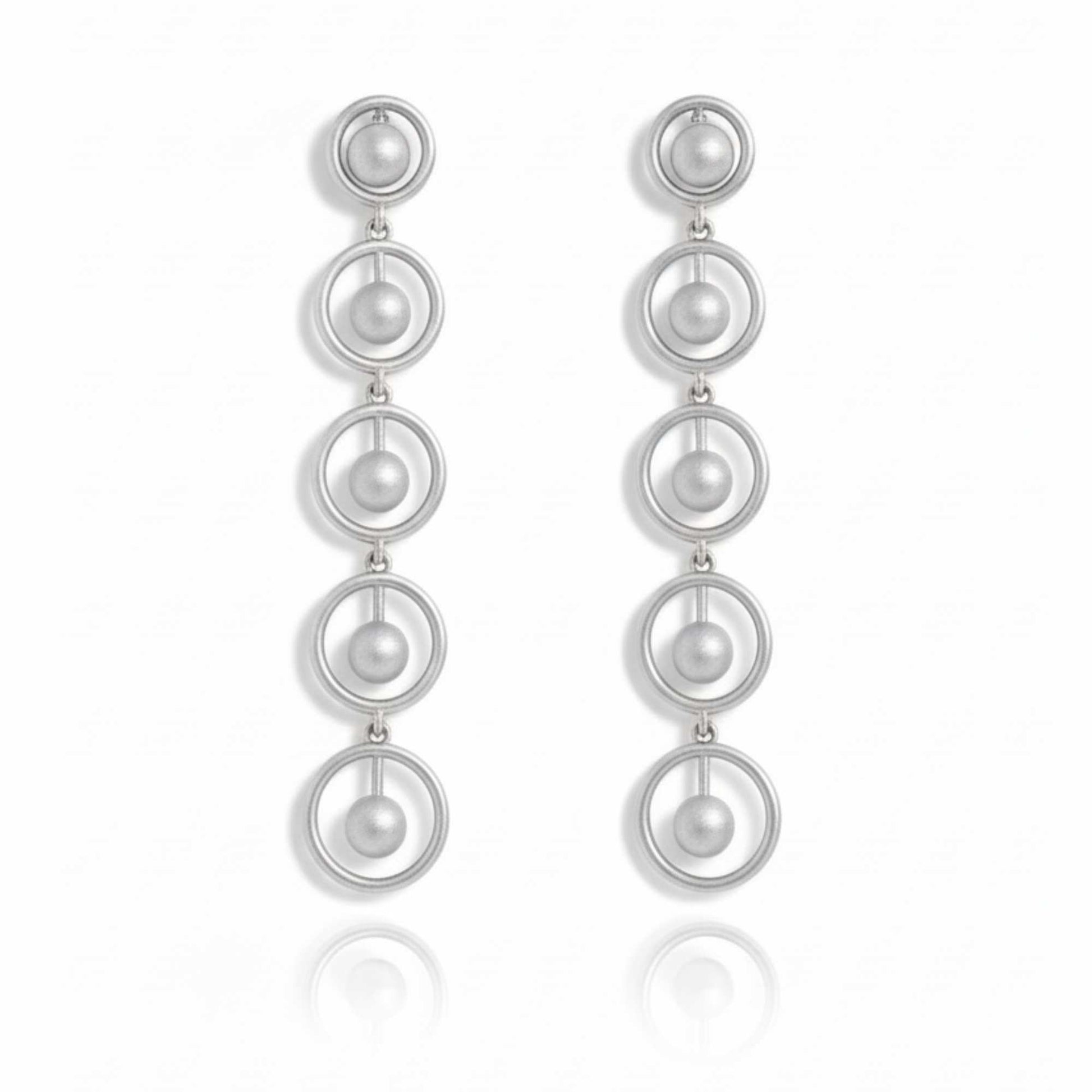 Silver earrings with multiple circular loops on a white background. solara earrings from house of pehr