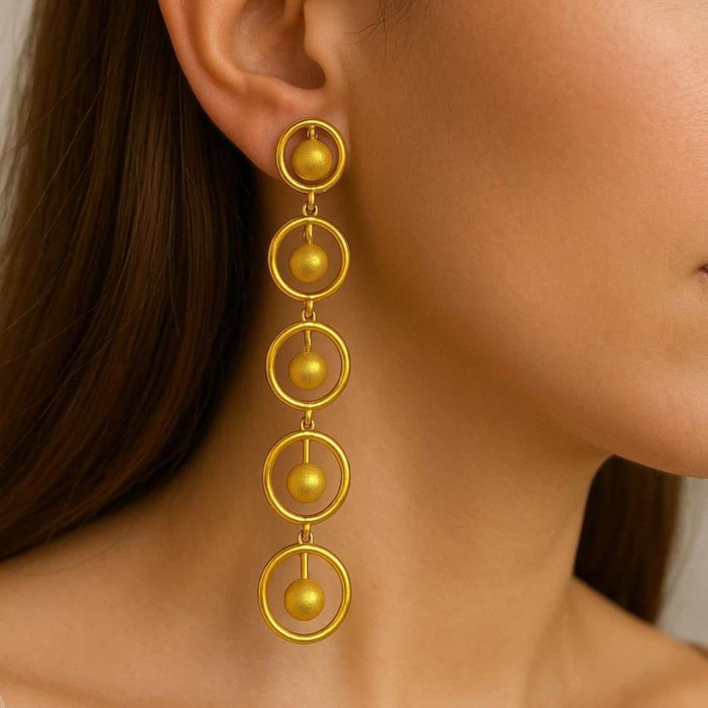 Gold earrings with circular design on a white background, solara earrings from house of pehr