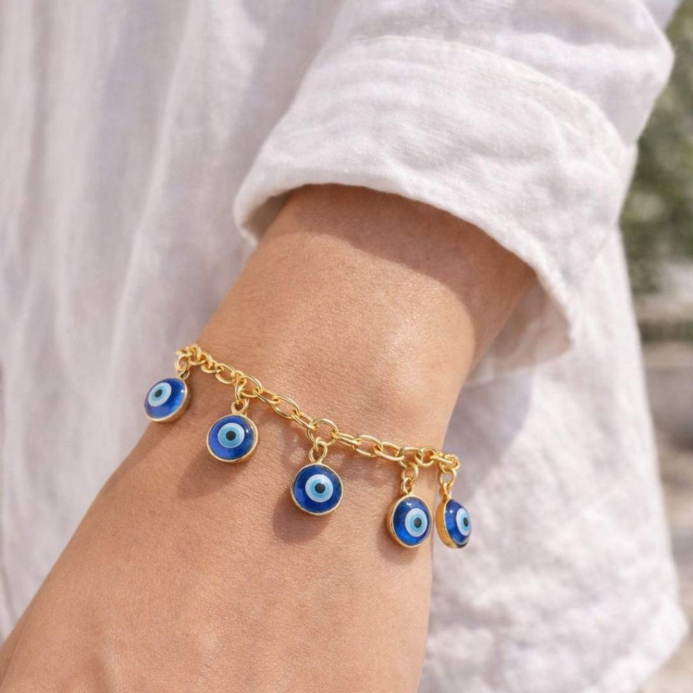 Gold bracelet with blue evil eye charms on a wrist against a white background from House of Pehr - Image 3