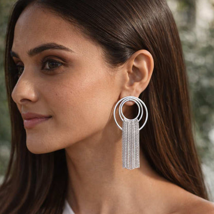 Woman wearing a silver hoop earring with tassels from House of Pehr