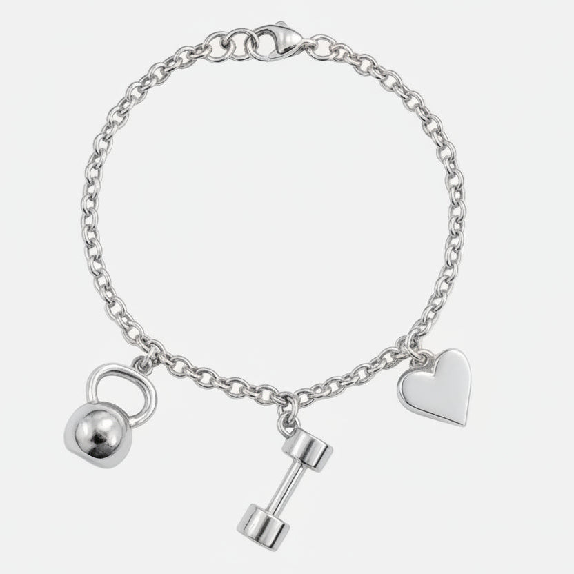 Silver bracelet with heart, dumbbell, and kettlebell charms on a white background. Invica bracelet from House of Pehr - Image 4