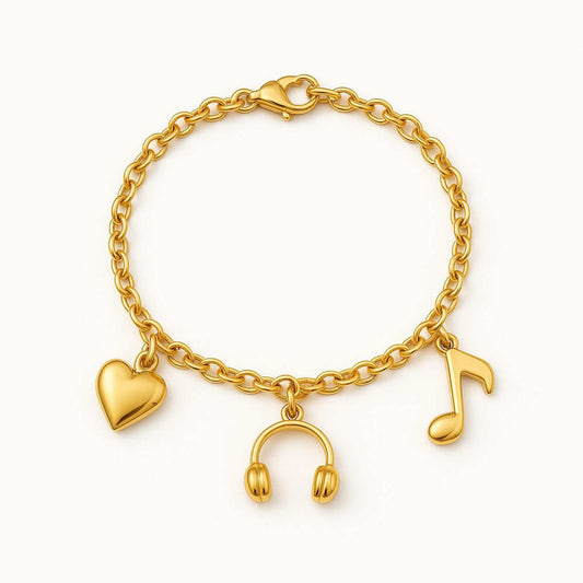Gold bracelet with heart, headphone, and music note charms on a white background. Cadence Bracelet from House of Pehr
