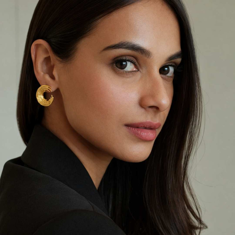 Woman wearing gold earrings with a neutral background from House of Pehr - Image 6