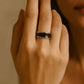 Close-up of a hand wearing a noire silver ring from House of Pehr
