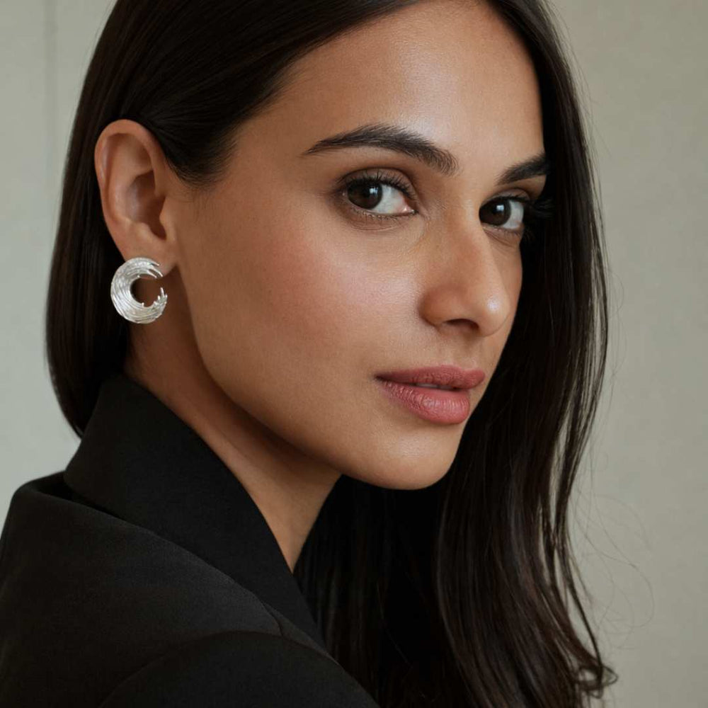 Woman wearing a silver earring with a neutral background from House of Pehr - Image 3