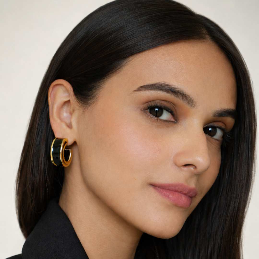 Close-up of a woman wearing gold hoop earrings with a neutral background House of Pehr