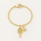 Gold watch charm with pickleball paddle and ball on a Watch against a blurred background