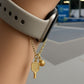 Gold watch charm with pickleball paddle and ball on a Watch against a blurred background