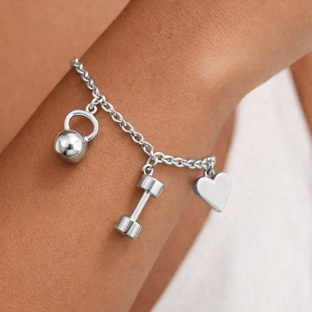 Silver Invicta bracelet with kettlebell, dumbbell, and heart charm on a wrist from House of Pehr - Image 2